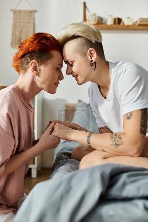 Two short-haired women, a lesbian couple, sitting on bed, sharing a loving look in a serene bedroom setting.
