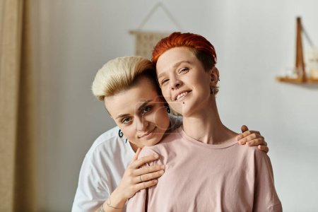 Photo for Two women with short hair are hugging each other affectionately in a cozy bedroom, showcasing the beauty of LGBT lifestyle. - Royalty Free Image
