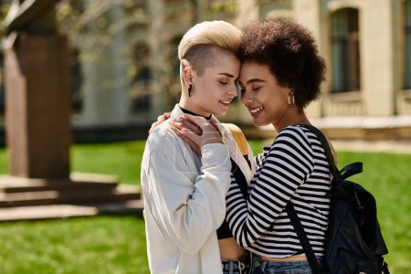 Dos jóvenes, pareja de lesbianas, comparten un cálido abrazo rodeado de naturaleza en un tranquilo entorno de parque.