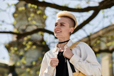 Photo for A stylish young woman with a short hair confidently carries a yellow bag while walking outdoors. - Royalty Free Image