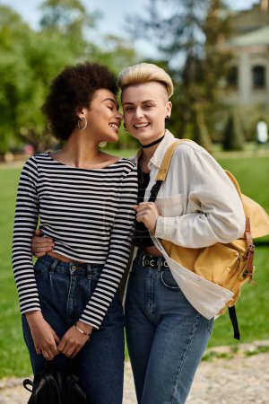 Photo for A pair of young women, stylish in casual attire, striking a pose together in a picturesque park - Royalty Free Image