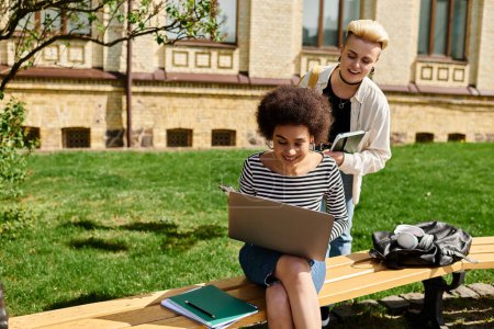 Photo for Two students, absorbed in their work, sit on a bench with a laptop. - Royalty Free Image
