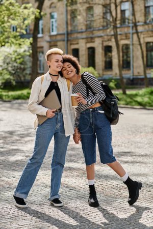 Multikulturelles lesbisches Paar in trendigen Outfits spaziert in der Nähe des Universitätscampus.