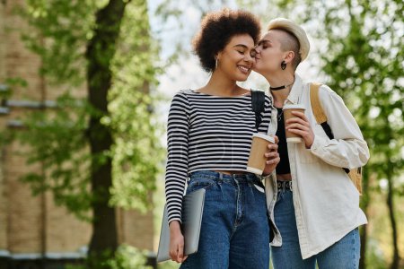 Téléchargez les photos : Un moment de tendresse alors que deux jeunes femmes, un couple lesbien multiculturel, partagent un baiser dans le parc, exprimant ouvertement leur amour. - en image libre de droit