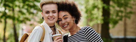 Foto de Dos mujeres jóvenes en un parque comparten un momento feliz, sonriéndose mutuamente en aprecio mutuo y amistad. - Imagen libre de derechos