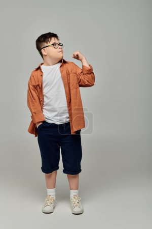 Adorable little boy with Down syndrome wearing glasses poses for the camera.