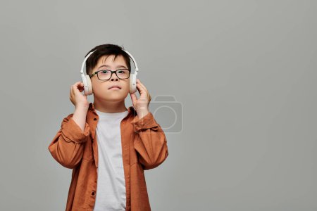 Charming boy with Down syndrome blissfully listens to music on headphones.