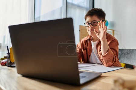 Photo for Little boy with Down syndrome at desk with laptop. - Royalty Free Image