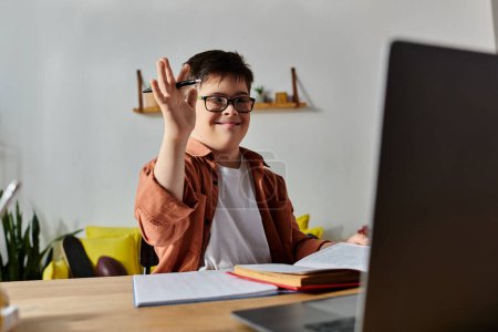 boy with Down syndrome at home desk using laptop.