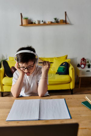 Junge mit Down-Syndrom trägt Kopfhörer, schreibt zu Hause in Notizbuch.