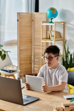 Little boy with Down syndrome immersed in laptop activities at table.