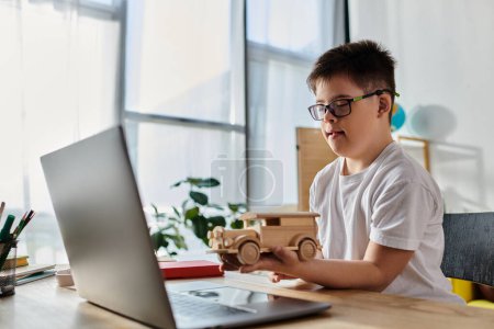 entzückender Junge mit Down-Syndrom spielt zu Hause kreativ mit Holzspielzeug am Laptop.