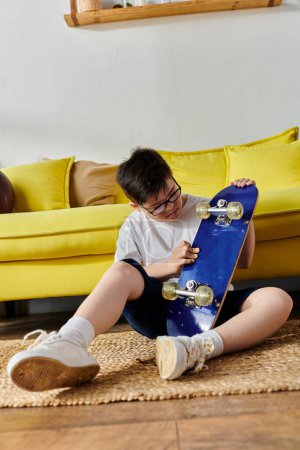 entzückender Junge mit Down-Syndrom, der mit Skateboard auf dem Boden sitzt.