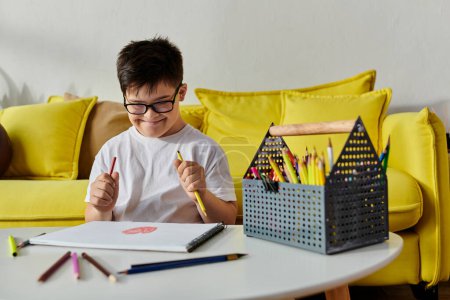 adorable chico con síndrome de Down sentado a la mesa con lápices de colores.