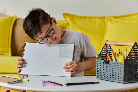 adorable boy with Down syndrome with glasses holds a piece of paper.