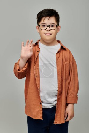 A charming little boy with Down syndrome, wearing glasses, strikes a pose for the camera.
