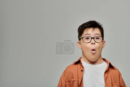 A little boy with Down syndrome makes a silly expression.
