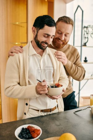 Glückliches homosexuelles Paar teilt eine Mahlzeit in einer modernen Küche und verbringt Zeit zusammen beim Frühstück.