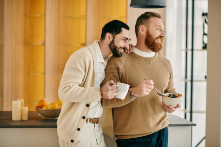 Dos hombres saborean una taza de café en una cocina, tomando el sol en compañía de los demás con sonrisas en un acogedor apartamento moderno.