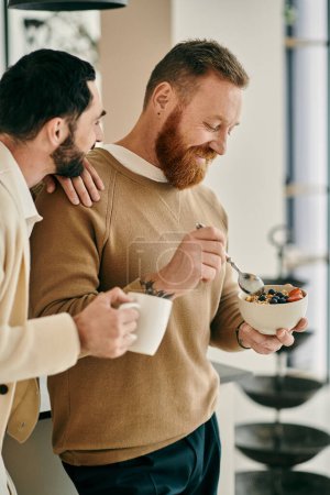 A happy gay couple shares a bowl of cereal in their modern kitchen, enjoying quality time together.