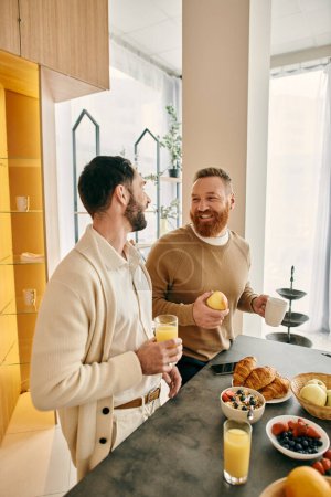 Zwei Männer genießen einen liebevollen Moment in der Küche, umgeben von Speisen und Getränken.