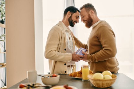 Foto de Dos hombres barbudos están en una cocina, compartiendo un momento de felicidad y conexión en su apartamento moderno. - Imagen libre de derechos