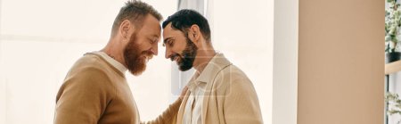 Foto de Two men in a modern apartment make eye contact, displaying love and connection in their relationship. - Imagen libre de derechos