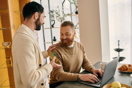 Zwei Männer, ein glückliches homosexuelles Paar, konzentrieren sich in der Nähe des Laptops