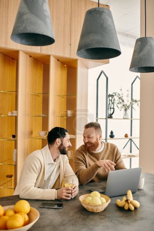 A happy gay couple sitting at a table in a modern kitchen, engrossed in conversation over coffee, enjoying each others company.