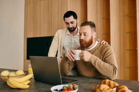 Zwei Männer, ein glückliches homosexuelles Paar, sitzen an einem Küchentisch, vertieft in einen Laptop-Bildschirm und schaffen ein Band gemeinsamen Interesses und Liebe.