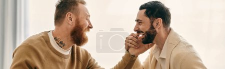 Deux hommes barbus s'engagent dans une conversation animée dans un appartement moderne, mettant en valeur le lien et la connexion entre eux.