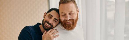 Téléchargez les photos : Two men in casual attire hug affectionately in front of a large window, embodying love and togetherness. - en image libre de droit