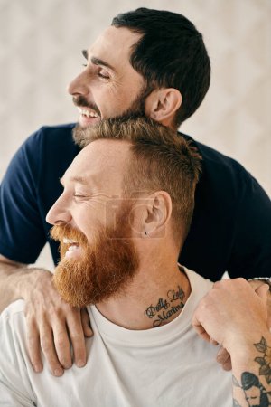 Two men, with tattoos on their arms, share a warm hug in a display of love and affection.