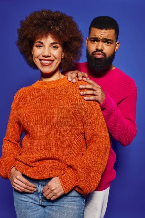 Foto de Un joven hombre y una mujer afroamericanos en vibrante atuendo casual se mantienen lado a lado, irradiando amistad y diversidad. - Imagen libre de derechos