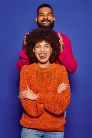 Foto de Un joven afroamericano hombre y mujer de pie uno al lado del otro con vibrante atuendo casual, mostrando su fuerte vínculo de amistad. - Imagen libre de derechos