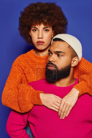 A young man with a beard and a woman in a sweater, showcasing a strong bond of friendship on a blue background.