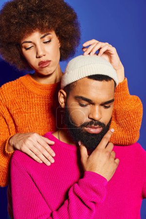Foto de Un joven afroamericano con barba y una mujer afro que muestra amistad y diversidad cultural con un atuendo vibrante. - Imagen libre de derechos
