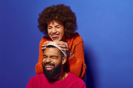 Téléchargez les photos : Jeune homme et femme afro-américain en tenue vibrante riant ensemble, mettant en valeur l'amitié et la camaraderie. - en image libre de droit