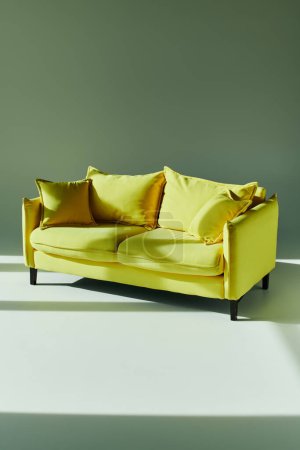Foto de Un sofá amarillo se destaca en un suelo blanco, aportando calidez y vitalidad a los alrededores, por lo demás llanos. - Imagen libre de derechos
