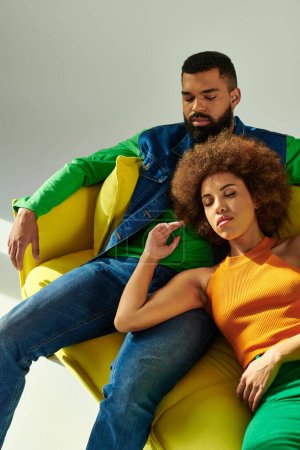 Téléchargez les photos : Amis afro-américains en tenue élégante profiter de l'autre compagnie tout en se prélassant sur un canapé - en image libre de droit