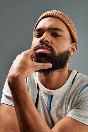 Téléchargez les photos : Un Afro-Américain avec une barbe porte avec confiance un chapeau, exsudant un sens du style et du charisme - en image libre de droit