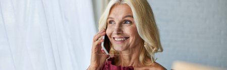 Photo for Stylish woman in elegant dress smiling while chatting on cellphone. - Royalty Free Image
