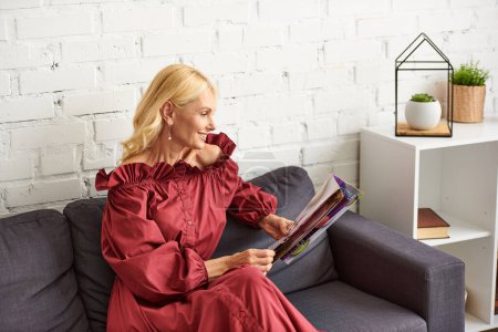 Femme sophistiquée en tenue élégante captivée par un magazine sur un canapé confortable.