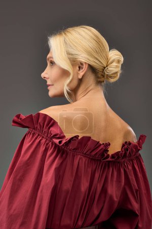 Mature woman in red blouse and high ponytail.