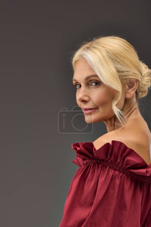 Mature, elegant woman with blonde hair in a red dress.