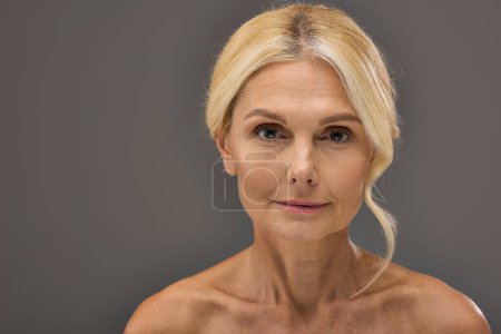 Téléchargez les photos : Mature woman with blonde hair looking directly at the viewer. - en image libre de droit
