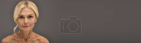 Téléchargez les photos : Femme blonde mature posant gracieusement et regardant la caméra. - en image libre de droit