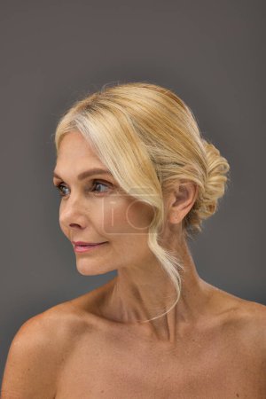 Photo for Mature woman with blonde hair elegantly looking away. - Royalty Free Image