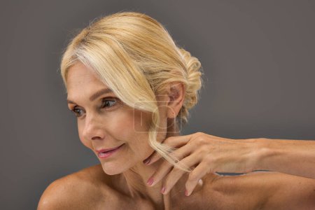 Téléchargez les photos : Femme mûre aux cheveux blonds posant pour un portrait. - en image libre de droit