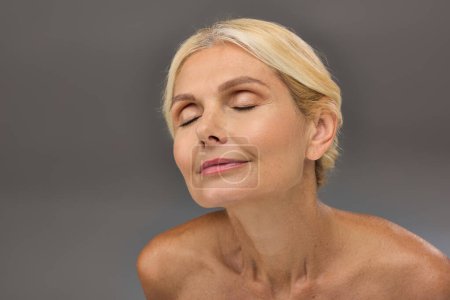Mature woman peacefully posing with eyes gently closed.